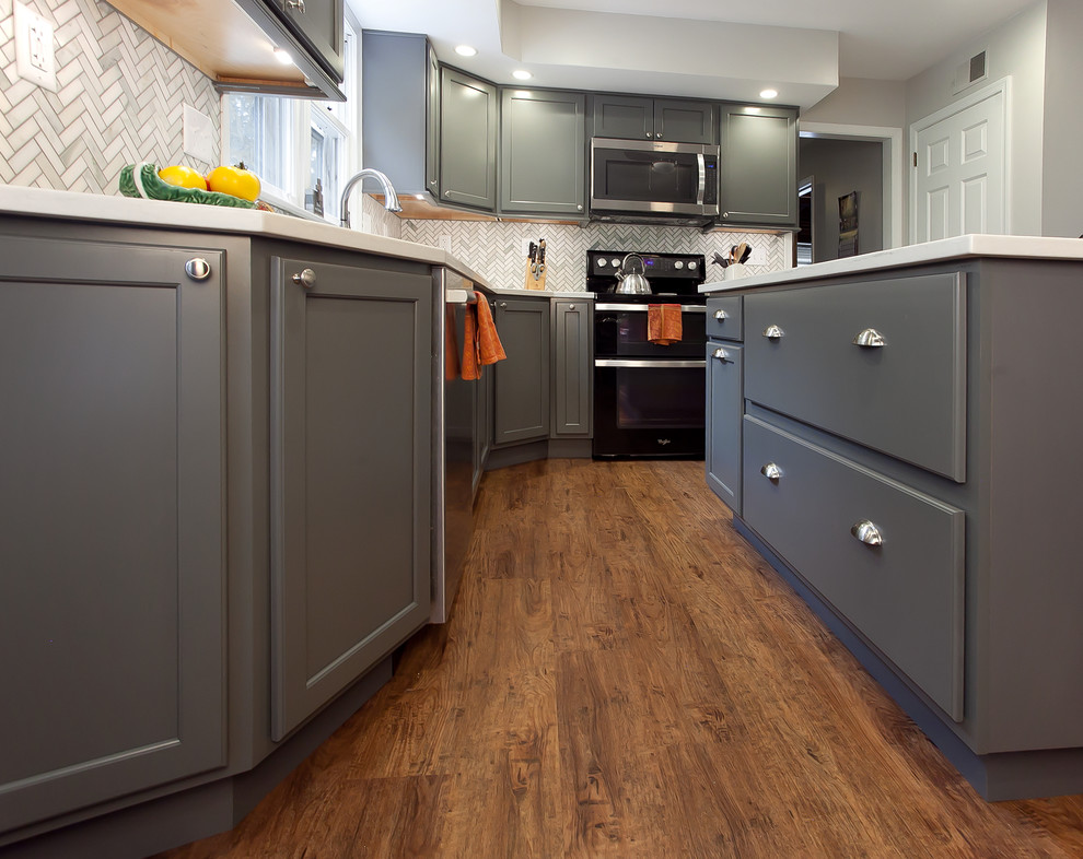 Inspiration for a mid-sized transitional l-shaped eat-in kitchen in Philadelphia with an undermount sink, recessed-panel cabinets, grey cabinets, quartz benchtops, grey splashback, marble splashback, stainless steel appliances, vinyl floors, with island and brown floor.