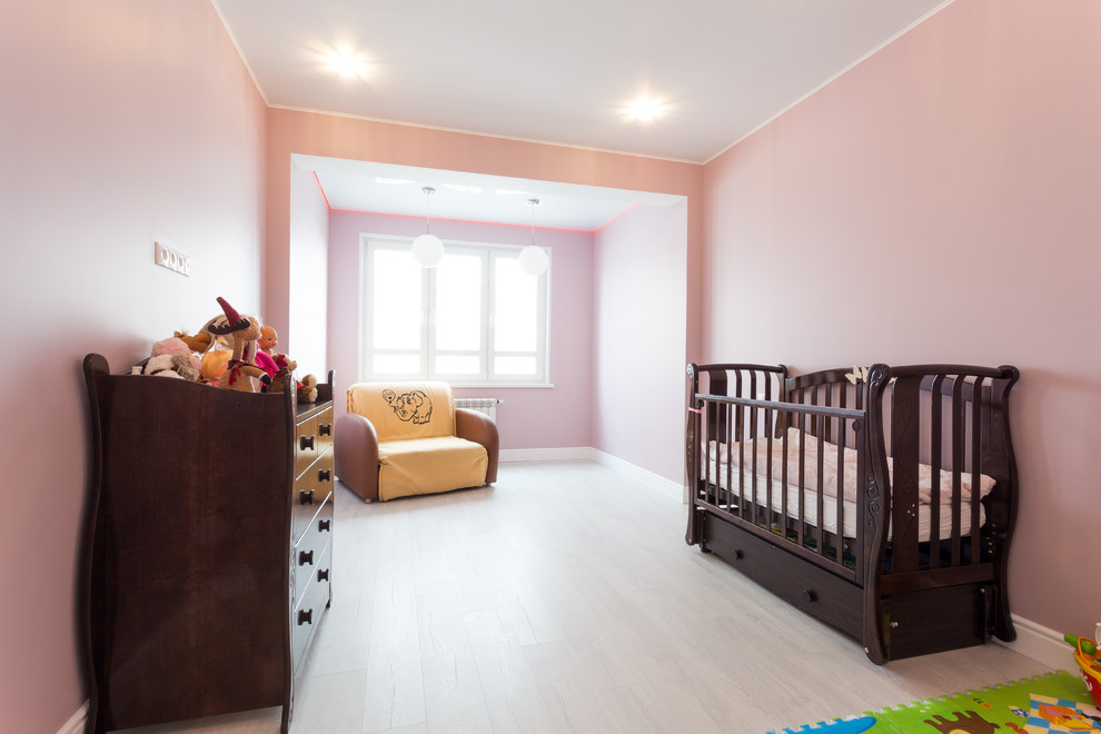 Exemple d'une petite chambre de bébé chic.
