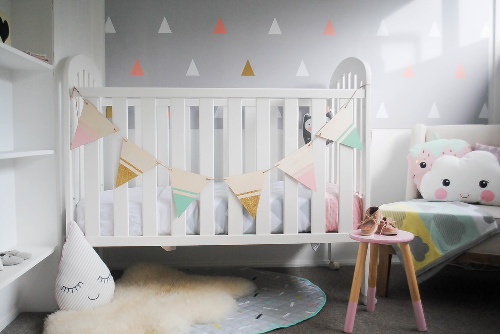 Example of a mid-sized transitional girl carpeted nursery design in Auckland with gray walls
