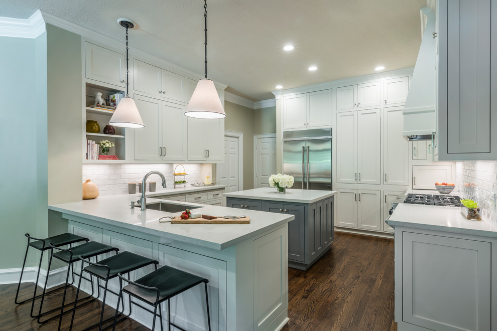 Open concept kitchen - mid-sized transitional medium tone wood floor open concept kitchen idea in Houston with an undermount sink, shaker cabinets, white cabinets, quartz countertops, white backsplash, subway tile backsplash, stainless steel appliances and an island