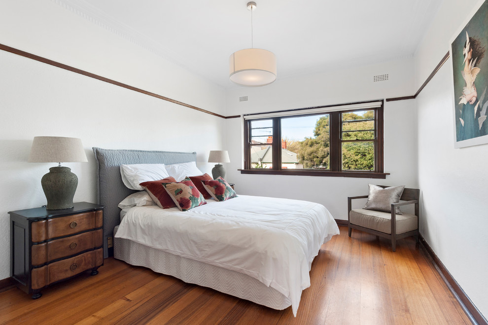 Photo of a mid-sized contemporary master bedroom in Melbourne with white walls, medium hardwood floors and brown floor.