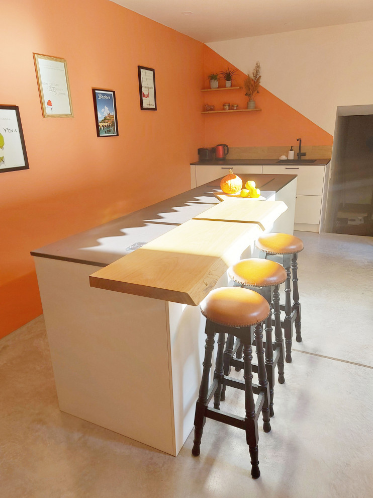 Esempio di una cucina contemporanea di medie dimensioni con lavello integrato, ante a filo, ante bianche, top in quarzo composito, paraspruzzi in legno, pavimento in cemento, pavimento grigio e top grigio