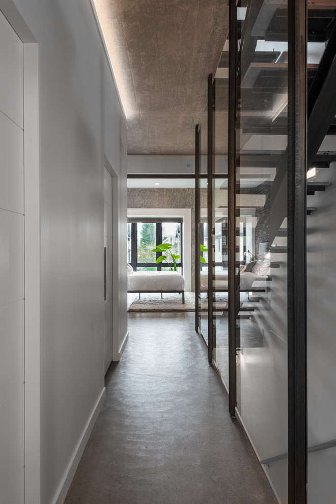 Photo of a small contemporary hallway in Seattle with white walls, concrete floors and grey floor.