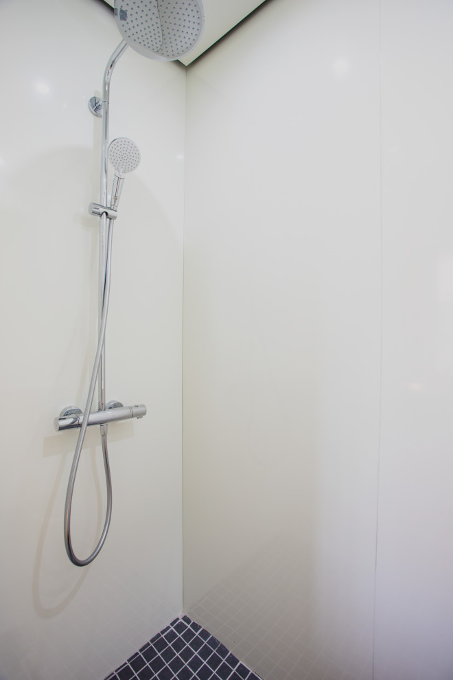 This is an example of a small scandi shower room bathroom in Nice with a built-in shower, a wall mounted toilet, white walls, ceramic flooring, black floors, a hinged door and a floating vanity unit.
