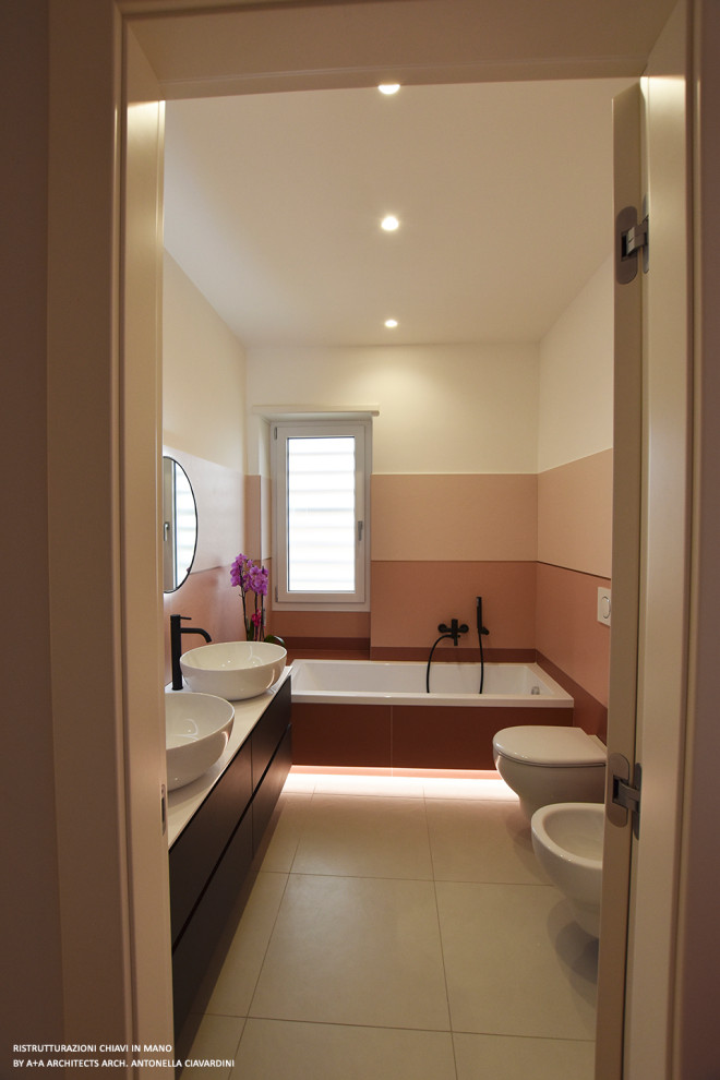 Large contemporary family bathroom in Other with flat-panel cabinets, grey cabinets, a built-in bath, a wall mounted toilet, pink tiles, porcelain tiles, white walls, porcelain flooring, a vessel sink, grey floors, white worktops, double sinks and a floating vanity unit.