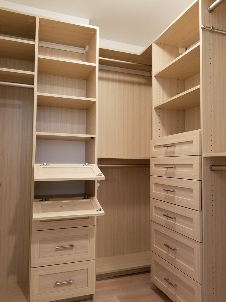 Inspiration for a small modern gender-neutral walk-in wardrobe in New York with shaker cabinets, light wood cabinets and light hardwood floors.