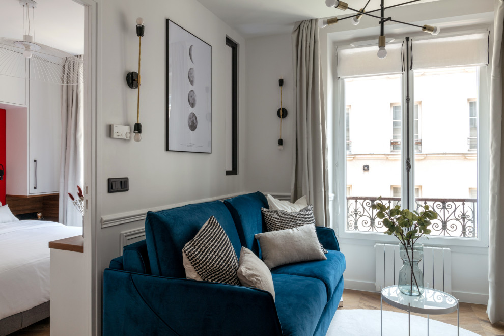 Immagine di un piccolo soggiorno design con pareti bianche, pavimento in legno massello medio, TV a parete e pavimento marrone