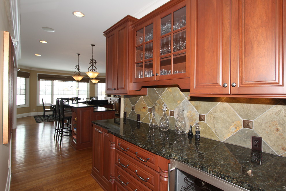 This is an example of a mid-sized transitional home bar in Cincinnati with slate splashback.