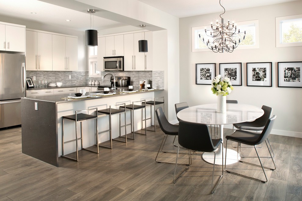 Contemporary kitchen/dining combo in Edmonton with white walls and brown floor.