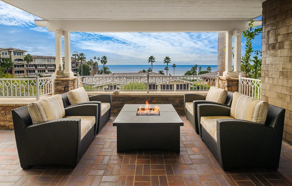 Example of a classic brick patio design in Denver with a fire pit and a pergola