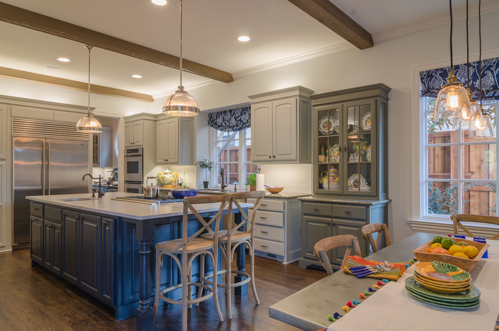 Design ideas for a traditional l-shaped open plan kitchen in Dallas with raised-panel cabinets, beige cabinets, white splashback, subway tile splashback, stainless steel appliances, dark hardwood floors, with island and granite benchtops.