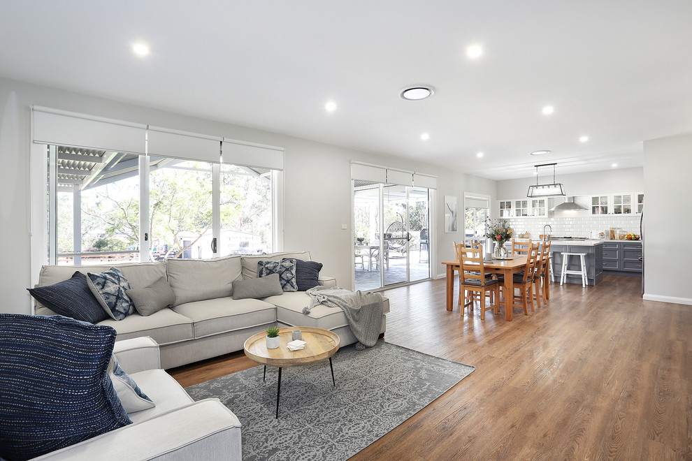 Transitional open concept living room in Sydney with grey walls, medium hardwood floors and brown floor.
