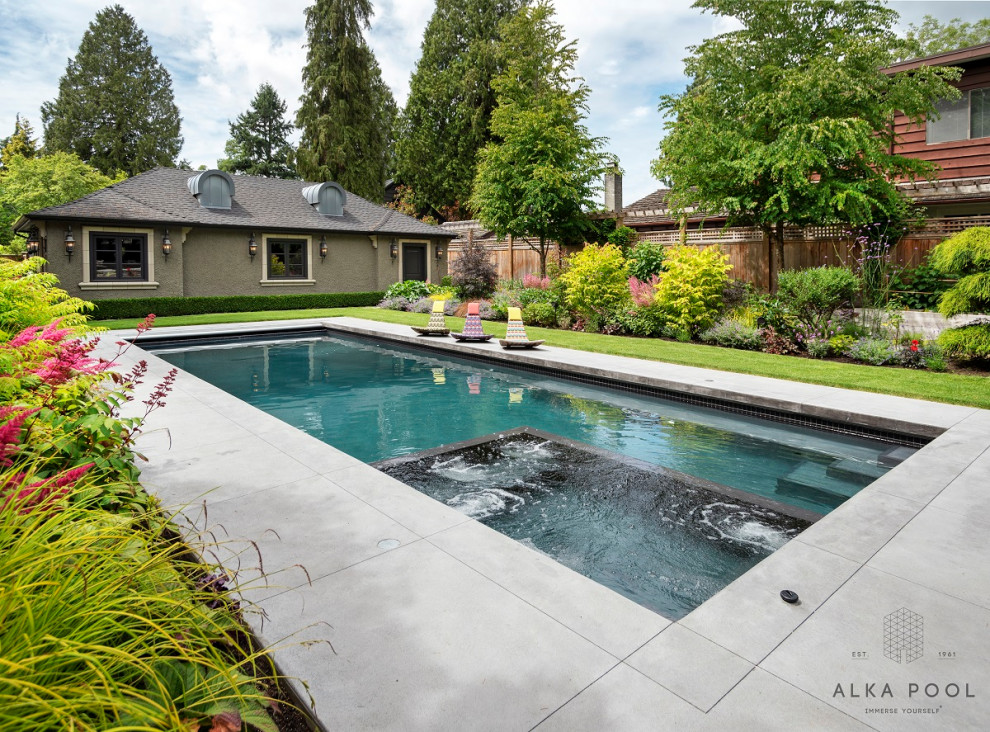 Photo of a traditional backyard rectangular pool in Vancouver with a hot tub.
