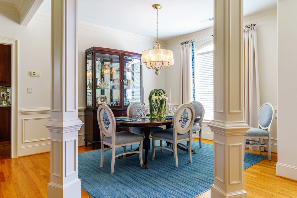 Mid-sized transitional medium tone wood floor and brown floor dining room photo with white walls and no fireplace