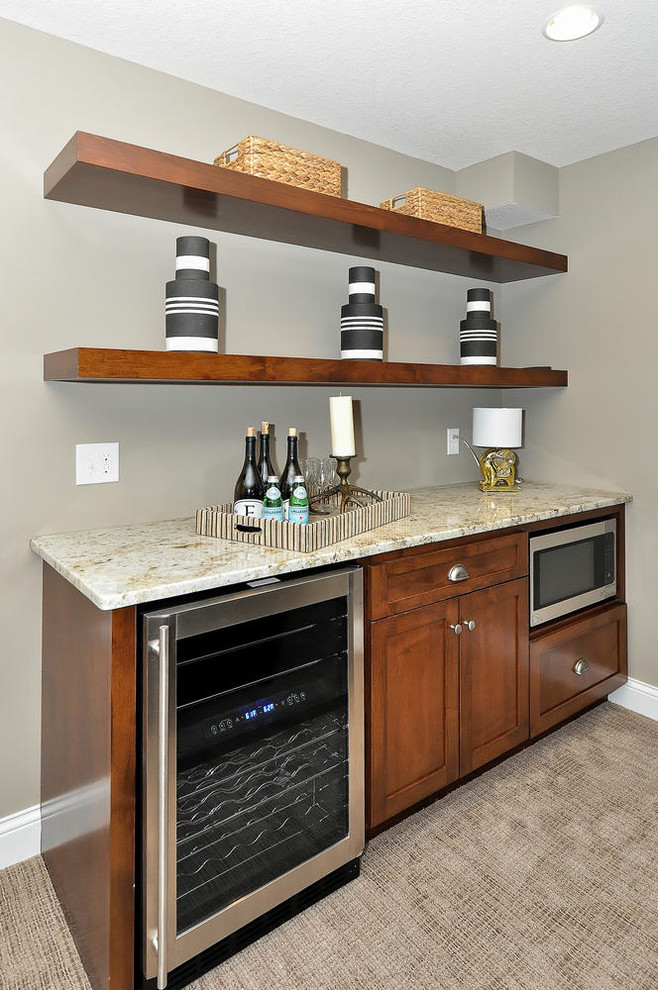 Photo of a small transitional single-wall wet bar in Minneapolis with open cabinets, medium wood cabinets, granite benchtops, carpet, brown floor and beige benchtop.