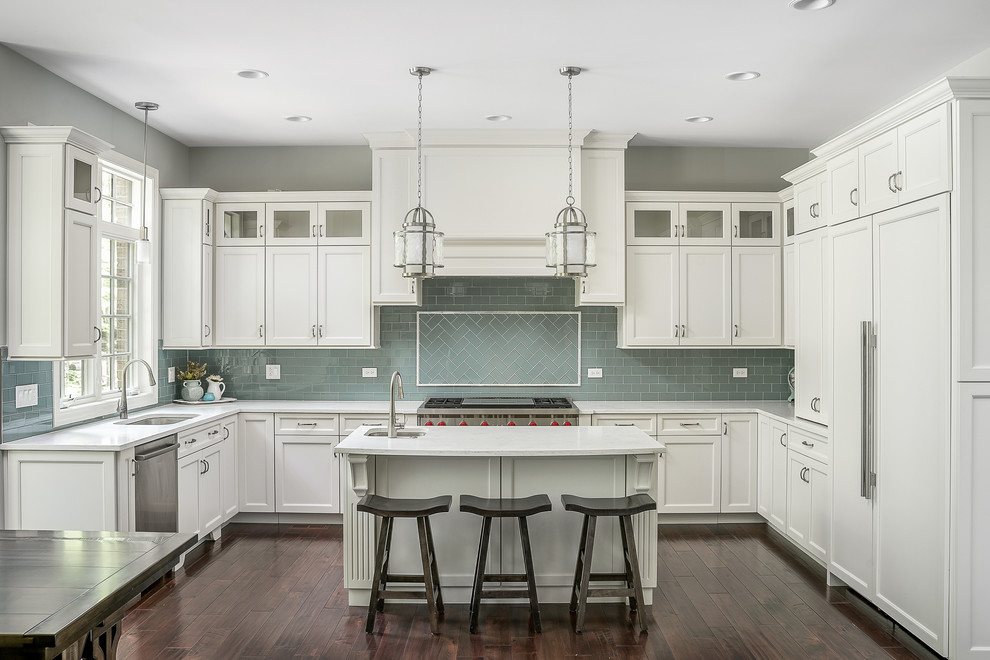Traditional u-shaped separate kitchen in Chicago with an undermount sink, recessed-panel cabinets, white cabinets, blue splashback, subway tile splashback, panelled appliances, dark hardwood floors, with island and brown floor.