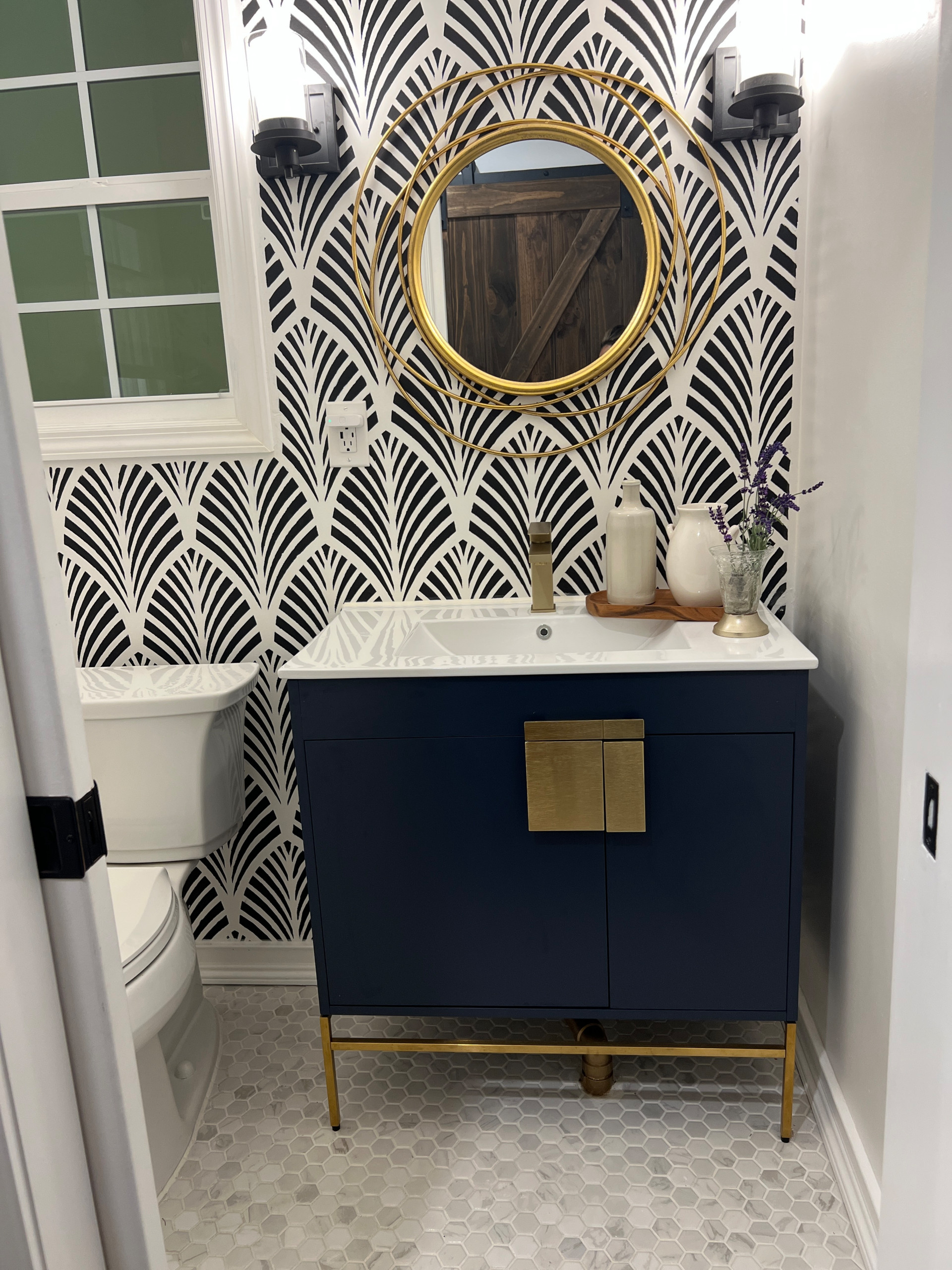 Impactful rendition of a updated powder room in a modern style.  Beautiful black and white feature wall draws the perfect interest.