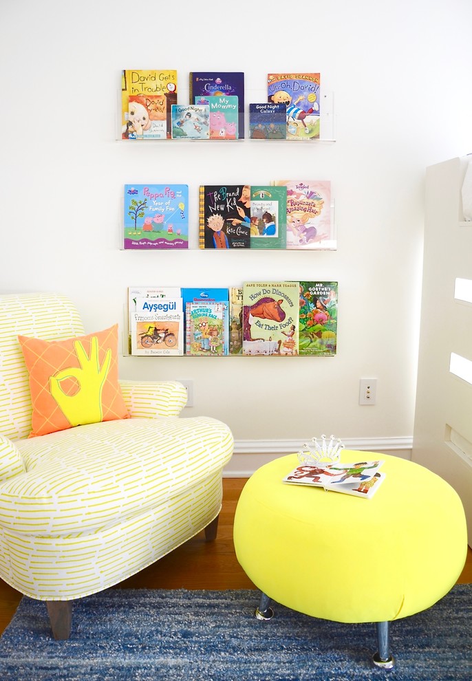Photo of a mid-sized transitional gender-neutral kids' playroom for kids 4-10 years old in New York with multi-coloured walls, light hardwood floors and beige floor.
