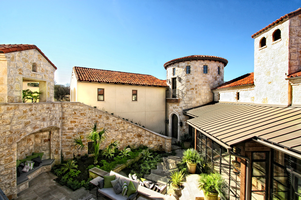 Photo of a mediterranean exterior in Austin with stone veneer.