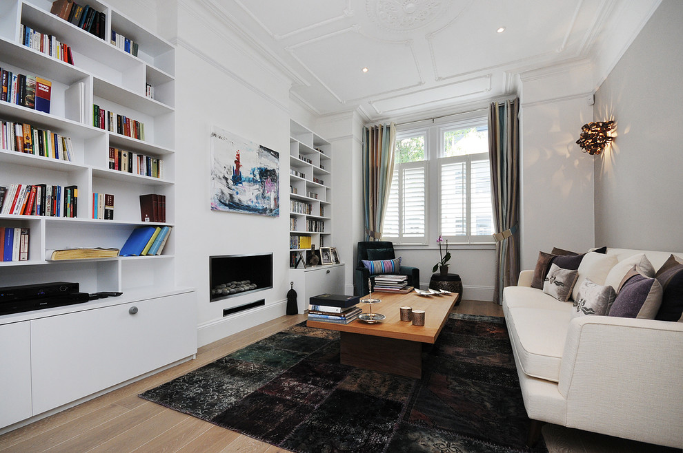 Contemporary living room in London with grey walls and a library.