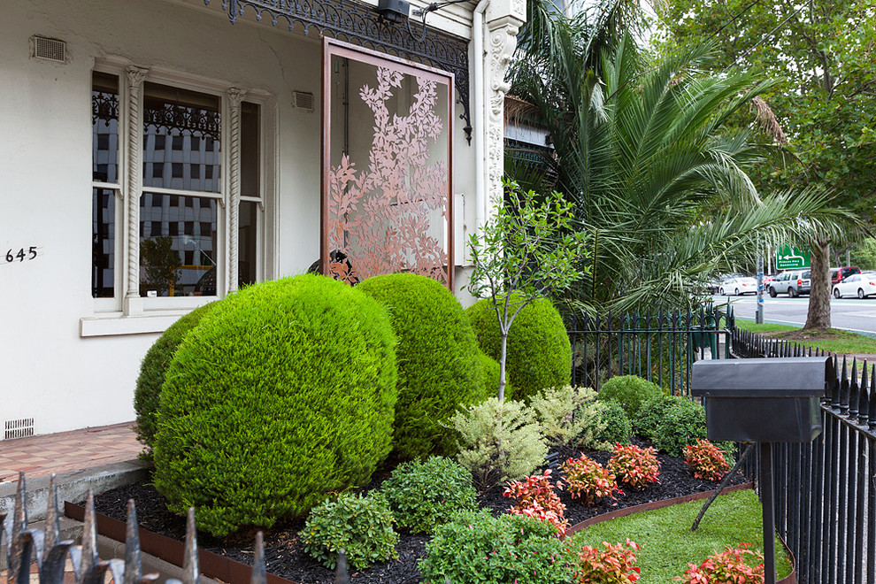 Small eclectic front yard full sun formal garden in Melbourne with brick pavers for summer.