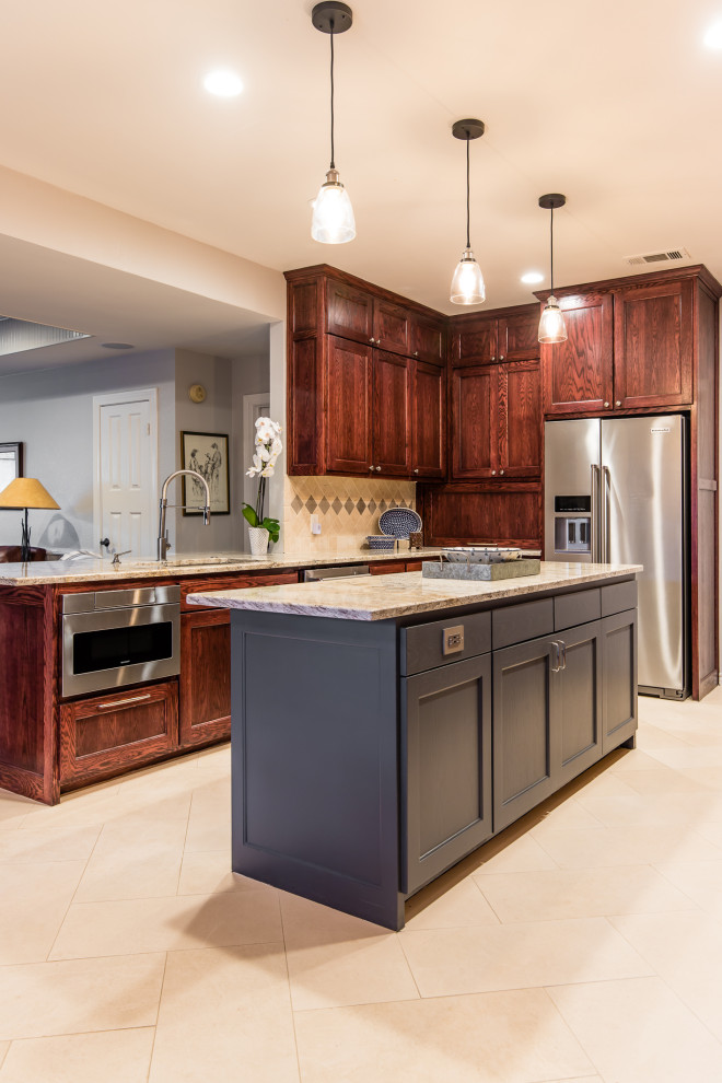 This is an example of a large traditional u-shaped eat-in kitchen in Dallas with an undermount sink, shaker cabinets, dark wood cabinets, granite benchtops, beige splashback, travertine splashback, stainless steel appliances, limestone floors, with island, beige floor and beige benchtop.