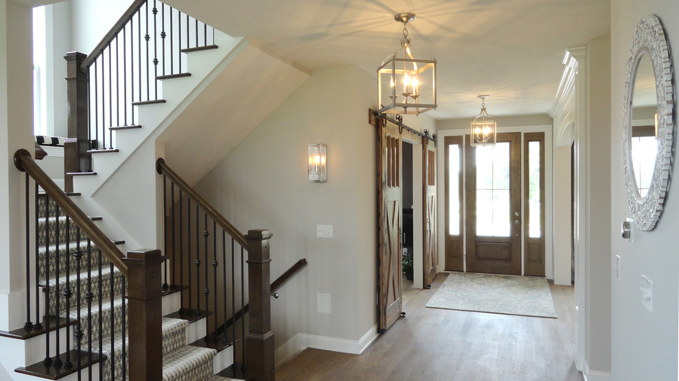 Inspiration for a mid-sized transitional foyer in Columbus with grey walls, medium hardwood floors, a single front door and a dark wood front door.
