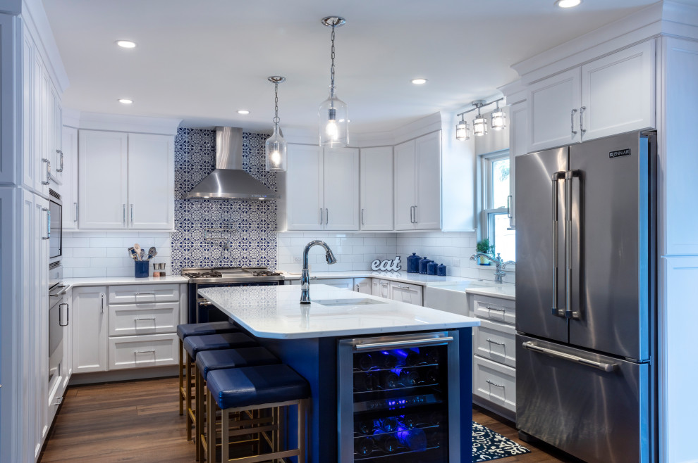 Inspiration for a transitional dark wood floor kitchen remodel with a farmhouse sink, shaker cabinets, white cabinets, quartz countertops, an island and white countertops