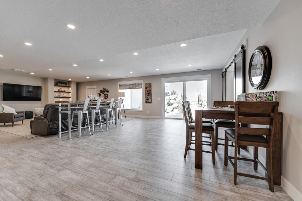 This is an example of a large arts and crafts walk-out basement in Salt Lake City with no fireplace, grey walls, porcelain floors and beige floor.
