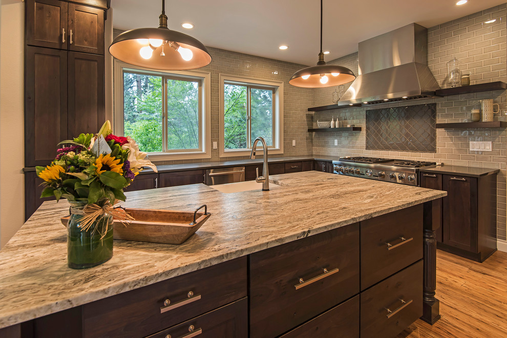 Inspiration for a large transitional l-shaped medium tone wood floor and brown floor open concept kitchen remodel with a farmhouse sink, shaker cabinets, dark wood cabinets, granite countertops, gray backsplash, subway tile backsplash, paneled appliances and an island