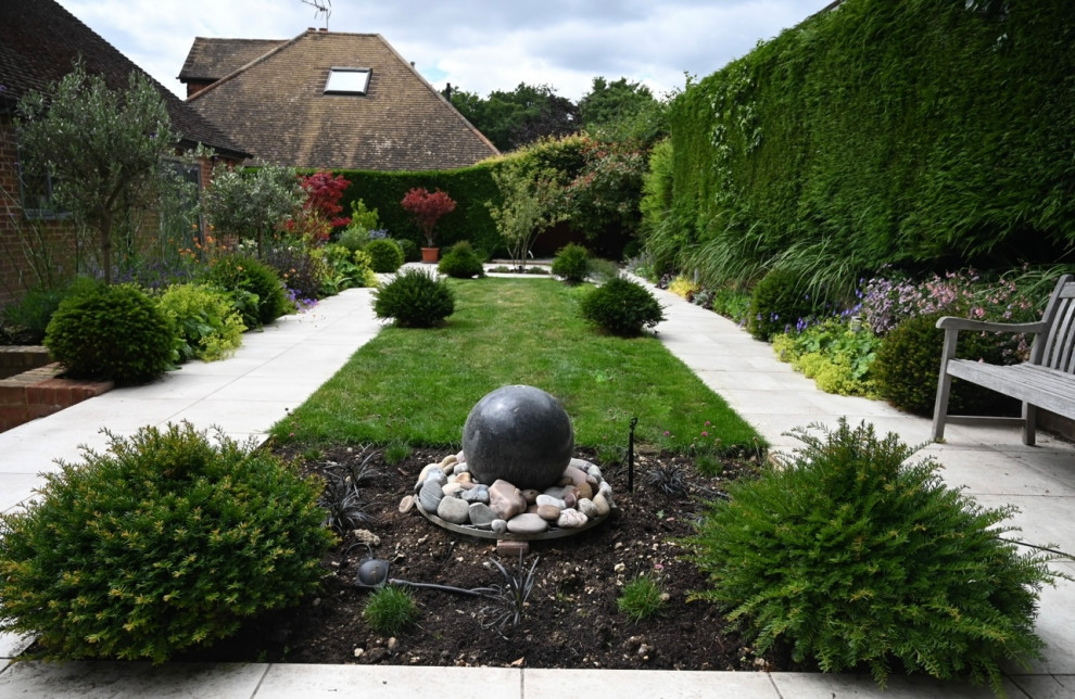 Exemple d'un jardin arrière tendance de taille moyenne et l'été avec une exposition ensoleillée, des pavés en pierre naturelle et une clôture en bois.
