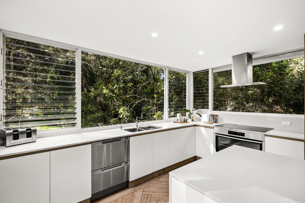 Photo of a mid-sized contemporary l-shaped eat-in kitchen in Sydney with an undermount sink, louvered cabinets, white cabinets, quartz benchtops, engineered quartz splashback, stainless steel appliances, cement tiles, with island, beige floor and white benchtop.