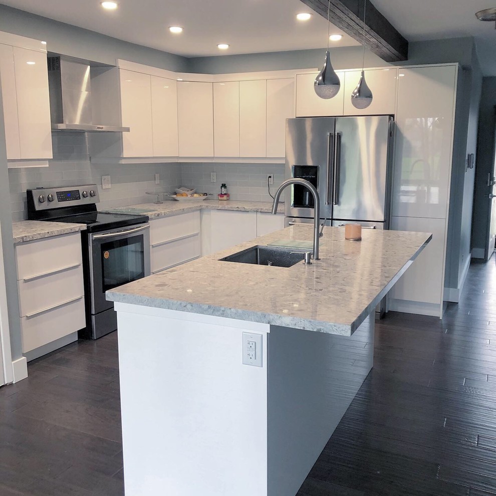 Mid-sized modern l-shaped eat-in kitchen in Toronto with flat-panel cabinets, white cabinets, marble benchtops, grey splashback, with island and grey benchtop.