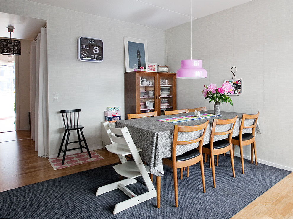 Photo of a mid-sized midcentury separate dining room in Stockholm with grey walls, medium hardwood floors and no fireplace.