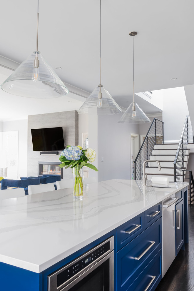 Open concept kitchen - large transitional l-shaped dark wood floor and brown floor open concept kitchen idea in Boston with an undermount sink, shaker cabinets, white cabinets, quartz countertops, white backsplash, marble backsplash, stainless steel appliances, an island and white countertops