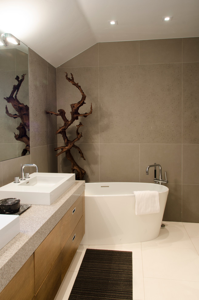 Inspiration for a small contemporary master bathroom in Denver with a vessel sink, flat-panel cabinets, medium wood cabinets, a freestanding tub, brown tile and brown walls.