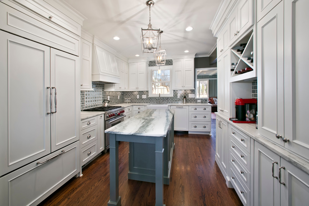Example of a mid-sized transitional u-shaped dark wood floor eat-in kitchen design in Minneapolis with a farmhouse sink, shaker cabinets, white cabinets, marble countertops, gray backsplash, subway tile backsplash, paneled appliances and an island