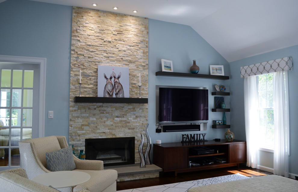 Mid-sized transitional enclosed family room in New York with blue walls, dark hardwood floors, a standard fireplace, a stone fireplace surround, a built-in media wall and brown floor.