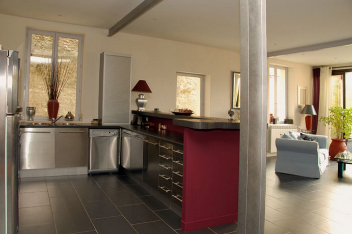 Exemple de cuisine américaine in L and inox With un évier 2 bacs, un plan de travail en stratifié, un sol en carrelage de céramique, une crédence rose and un sol noir.