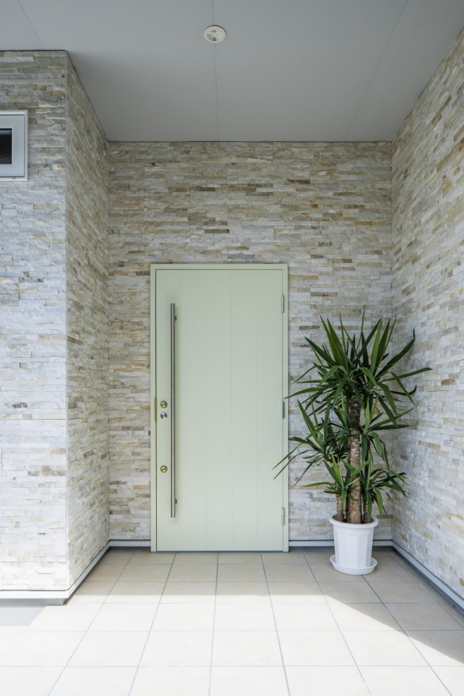 Bild på en mellanstor minimalistisk ingång och ytterdörr, med flerfärgade väggar, en enkeldörr och en grön dörr