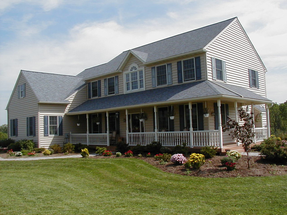 This is an example of a large country two-storey beige exterior in Philadelphia with vinyl siding and a gable roof.