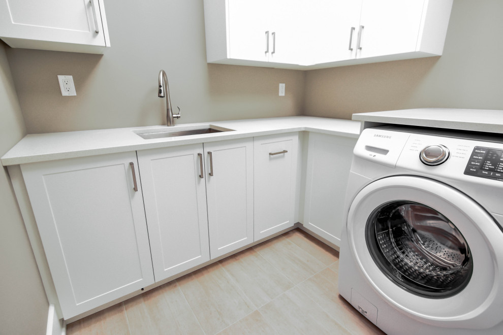 Minimalist ceramic tile dedicated laundry room photo in Edmonton with an undermount sink, shaker cabinets, white cabinets, granite countertops, a side-by-side washer/dryer and white countertops
