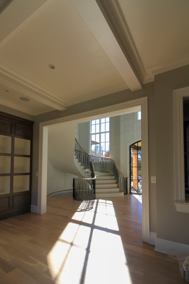 Inspiration for an expansive traditional wood curved mixed railing staircase in DC Metro with wood risers and wainscoting.