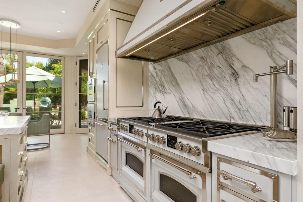 サンディエゴにあるラグジュアリーな巨大なコンテンポラリースタイルのおしゃれなキッチン (一体型シンク、ステンレスキャビネット、大理石カウンター、白いキッチンパネル、大理石のキッチンパネル、白い調理設備、ベージュの床、白いキッチンカウンター) の写真