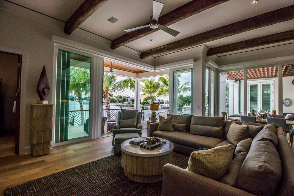 Inspiration for a mid-sized tropical formal open concept living room in Tampa with beige walls, medium hardwood floors, no fireplace, no tv and brown floor.