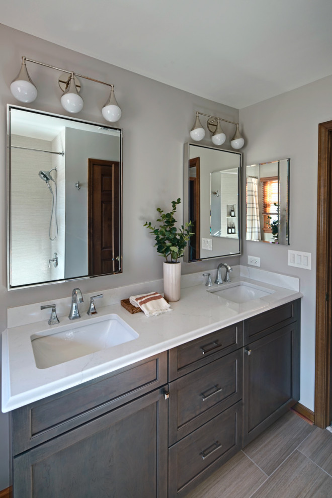 Drop-in bathtub - mid-sized transitional kids' beige tile and ceramic tile ceramic tile, gray floor and double-sink drop-in bathtub idea in Chicago with flat-panel cabinets, gray cabinets, a two-piece toilet, gray walls, an undermount sink, quartz countertops, white countertops, a niche and a built-in vanity