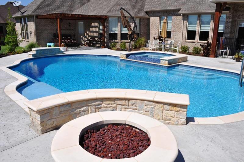 Design ideas for a mid-sized contemporary backyard custom-shaped lap pool in Orange County with a hot tub and natural stone pavers.