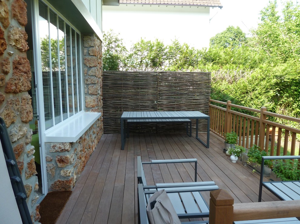 This is an example of a country backyard deck in Paris with no cover.