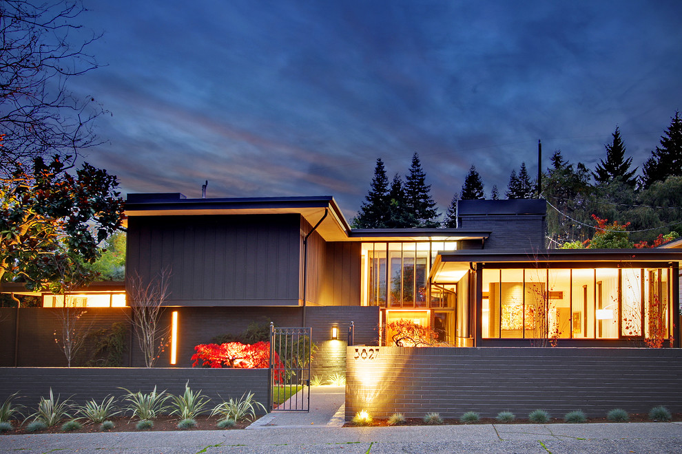 Inspiration for an expansive midcentury two-storey grey house exterior in Seattle with mixed siding and a flat roof.