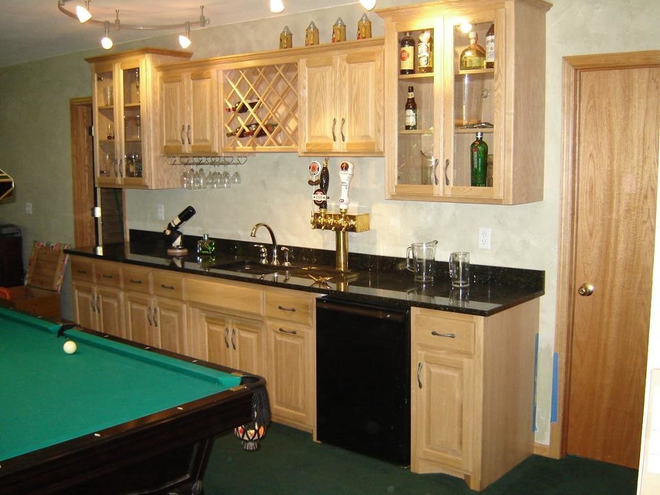 Inspiration for a mid-sized traditional single-wall wet bar in Minneapolis with an undermount sink, raised-panel cabinets, light wood cabinets, quartz benchtops, carpet and green floor.